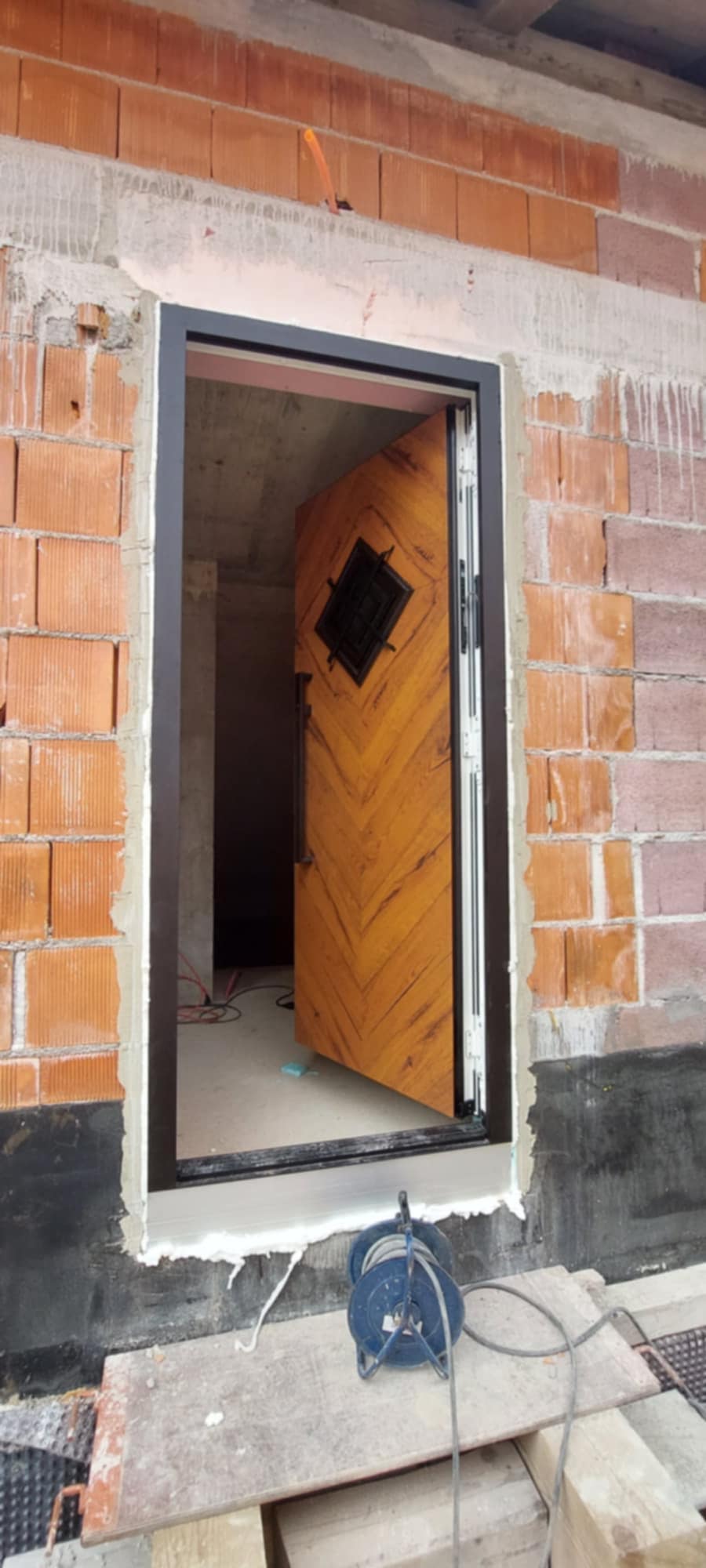 Montaža vhodnih vrat s poravnanim okvirjem in tesnjenjem