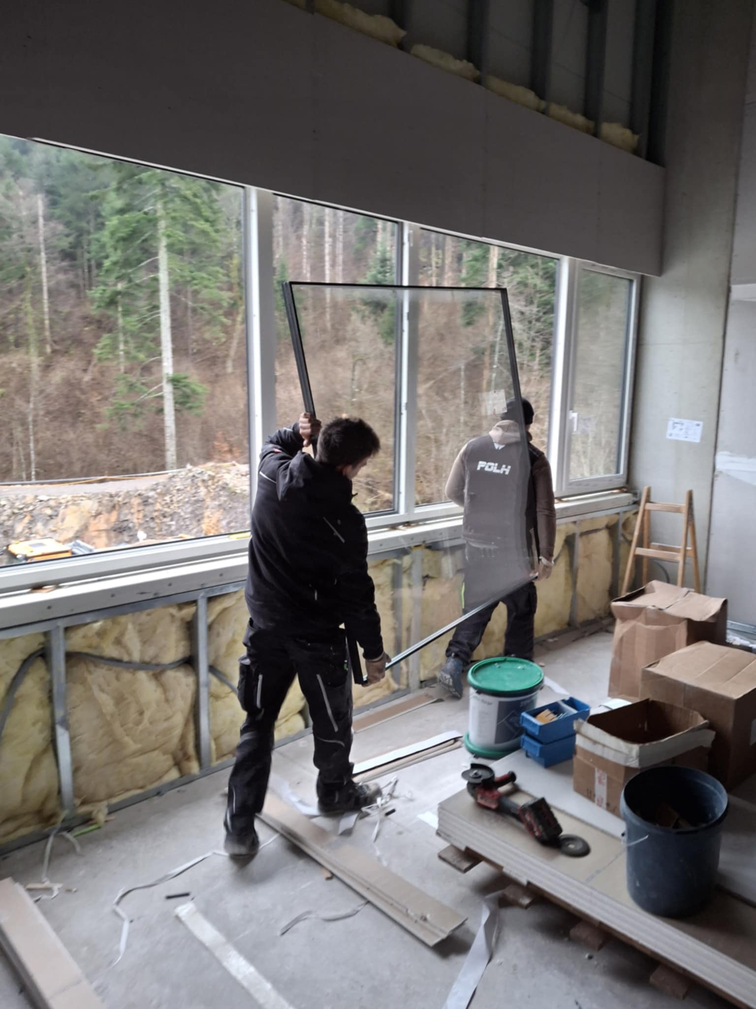 Ekipa med rokovanjem z zasteklitvijo pri montaži oken